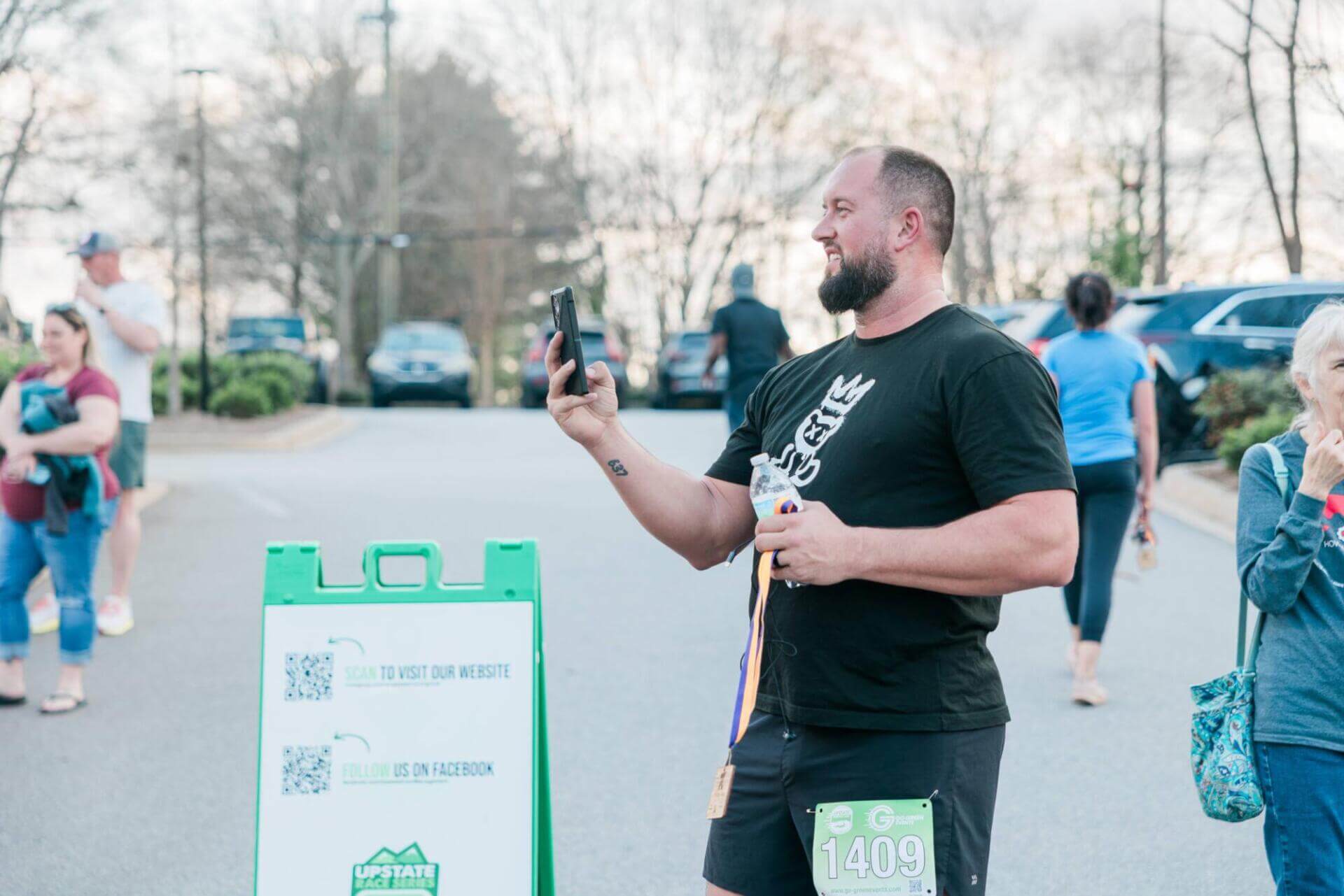 Один мужчина улыбается, делая снимок на телефон.