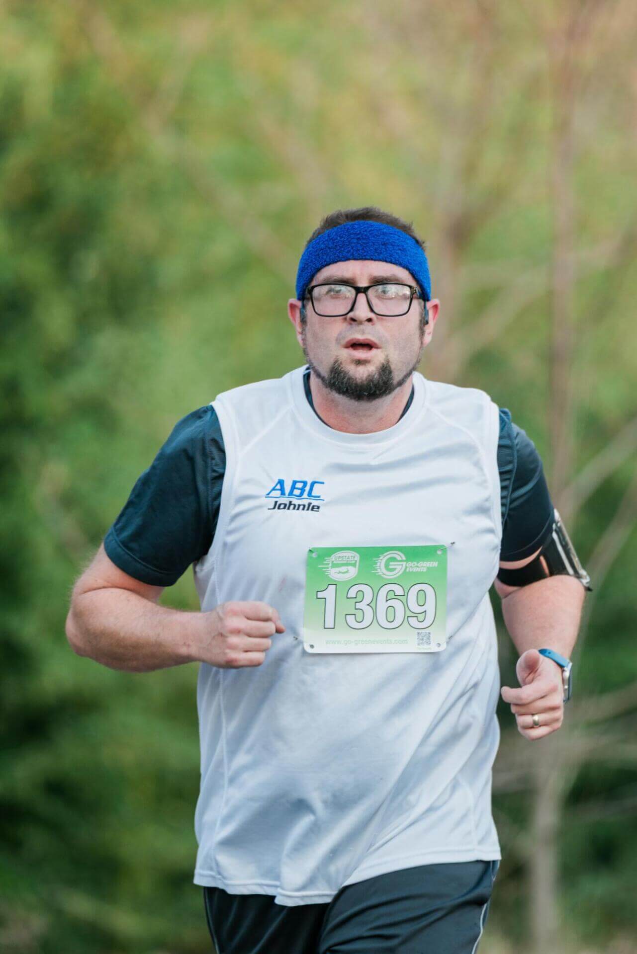 Мужчина бежит с номером 1369 на груди