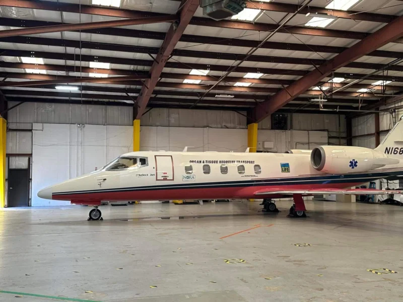 Частный самолет в просторном ангаре с надписью "Перевозка органов и тканей".