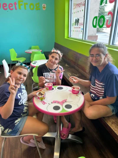 Три человека сидят за красочным столиком Sweet Frog